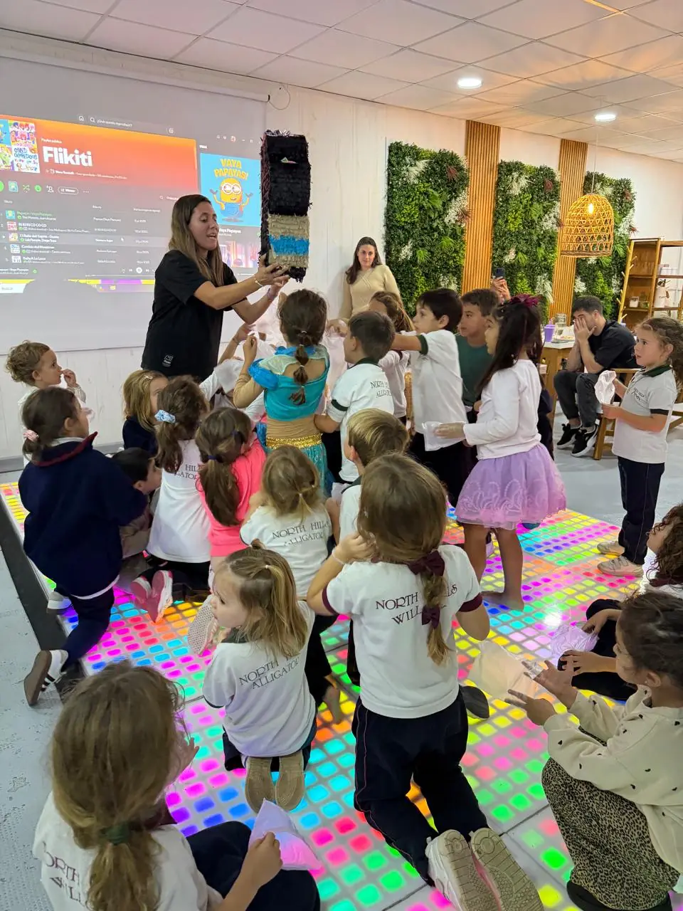 La animadora con la piñata y los chicos sobre la pista LED